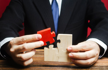 Businessman connects a red puzzle to the assembly. Business model planning and strategy, building a...