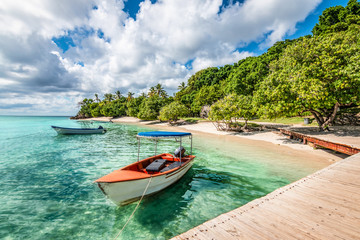 Small motorized boat at the pier and beach of Cayo Levantado Island, Samana Bay, Dominican Republic.
