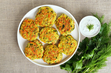 Tasty vegetable cutlets from zucchini, carrot, herbs in white plate