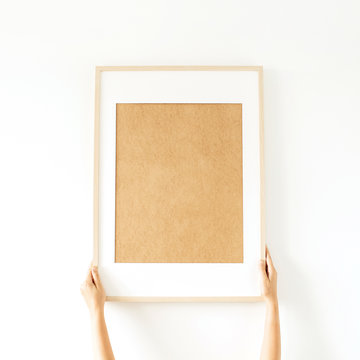 Blank photo frame with empty mockup copy space in women's hands. Minimal watercolor art concept.