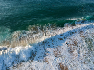 aerial view from a big wave crashing in a beach. Drone view