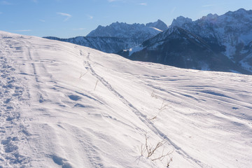 Blick aufs Kaisergebirge im Winter mit Schnee bei blauem Himmel und Sonne