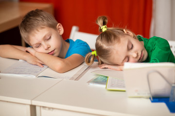 cute children of 8-9 years old, schoolchildren did homework at the table, do homework and fell asleep, sleep at the desk