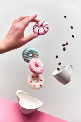 St. Valentine concept, levitation of doughnuts above heart shaped bowl. Coffee beans fly in...