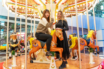 Fototapeta na wymiar couple of multiethnic young women having fun after shopping