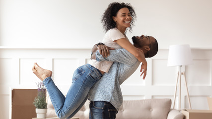 Successful black man raising up happy smiling wife.