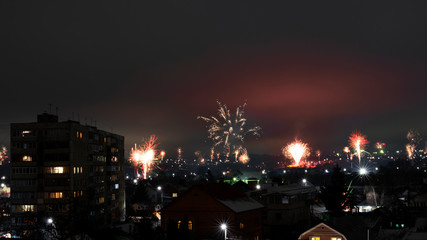 Night cityscape with lots of exploding holiday fireworks.