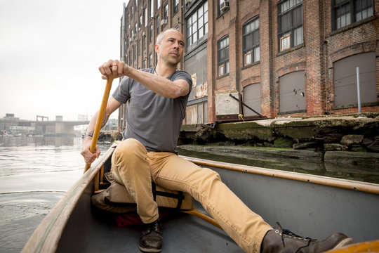 A man canoeing down a river in Brooklyn
