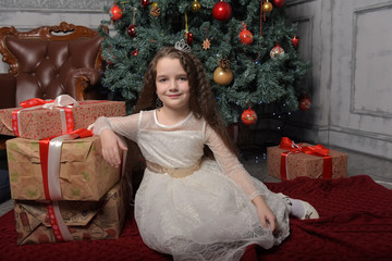 girl in ivory festive dress in christmas with a crown