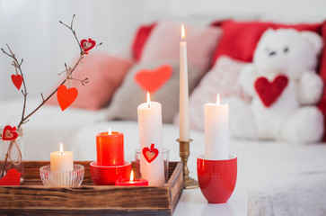 Burning candles on white table in interior. Valentines day conce