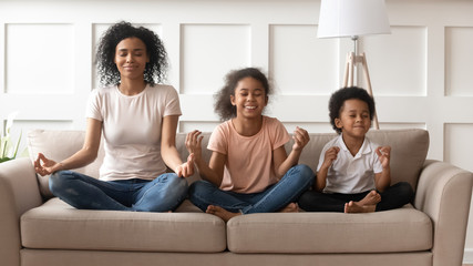 Happy black mother with son and daughter meditating.