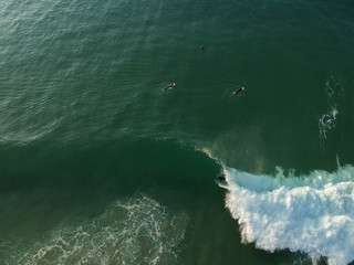 Surfers on a wave from an aerial perspective