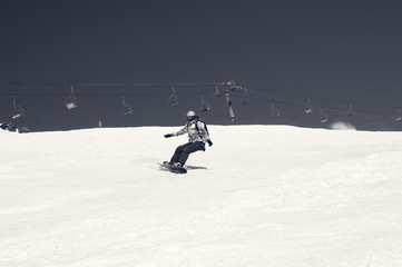 Snowboarder descends on snowy ski slope at winter