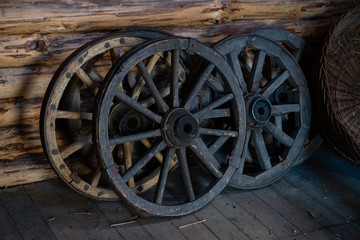 Fototapeta na wymiar Old wooden wheels from cart ukrainian national ancient transport in barn