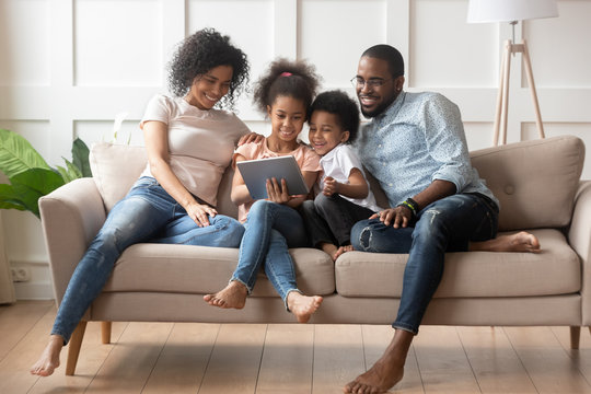 Happy african american family using tablet together.