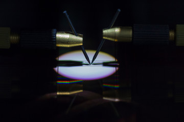 Manual probe system with needles for test of semiconductor on silicon wafer. Selective focus.