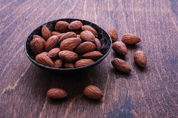 almonds in bowl on wooden table