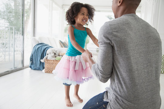 young girl in tutu dancing with her dad