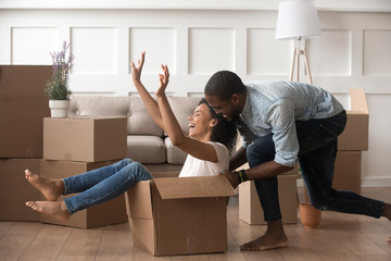 Excited laughing family couple playing in living room.