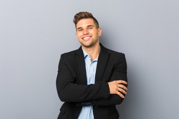 Young handsome caucasian man who feels confident, crossing arms with determination.