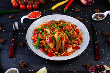 The concept of oriental cuisine. Assorted Uzbek food set, pilaf, samsa, lagman, manta, shurpa Uzbek restaurant concept, Uzbek food. Homemade Uzbek pilaf or plov from lamb served in cast iron cookware