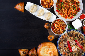 The concept of oriental cuisine. Assorted Uzbek food set, pilaf, samsa, lagman, manta, shurpa Uzbek restaurant concept, Uzbek food. Homemade Uzbek pilaf or plov from lamb served in cast iron cookware