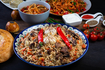 The concept of oriental cuisine. Assorted Uzbek food set, pilaf, samsa, lagman, manta, shurpa Uzbek...