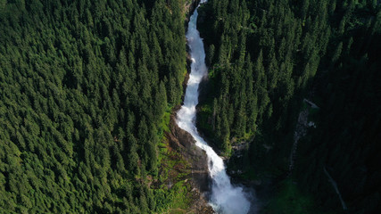 Obraz premium Aerial view of Krimml waterfall, cascades. Landscape with spruces, fir tree forest, stones, water flowing from mountains. Salzburg land, Austria.