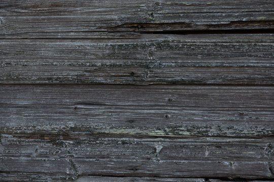 Fragment of an old wall made of horizontal wooden boards without paint. From time to time, the material became gray and textured. Background. Texture.
