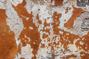Plastered wall of the old building. Old paint on the cracked plaster.