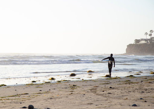 Surfer walking into the sunset