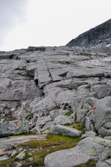 View to marked hiking trail to Tvillingene peak going up among grey granite cliffs in the mountain range of Seven Sisters 