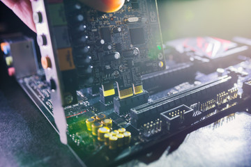 Proffesional soundcard being installed to motherboard by PC technician. PCI sound card upgrade or...