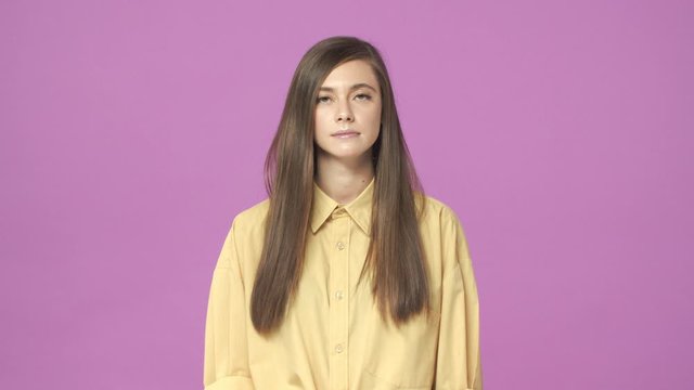 Slow-motion reluctant, unimpressed young tired girl, saying no, make eye roll bothered with dumb suggestion, reply no, make stop or cross gesture, disagree, deny something, purple background