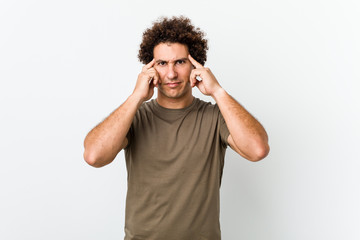 Fototapeta premium Dojrzały przystojny mężczyzna na białym tle koncentruje się na zadaniu, trzymając wskazujące głowę palce.