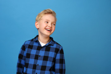 Smiling boy, happy child.  Happy, smiling boy on a blue background expresses emotions through...