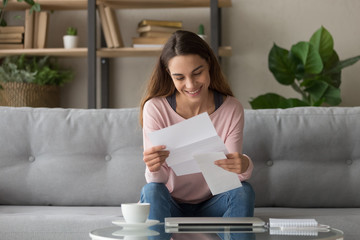 Happy smiling millennial girl holding paper document.