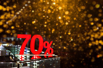 70 percent discount with golden bokeh background. Discounts in the shopping center. Seasonal sale,...
