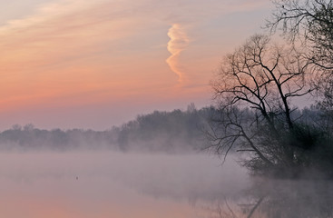 Foggy landscape at dawn of the shoreline of Jackson Hole Lake, Fort Custer State Park, Michigan, USA