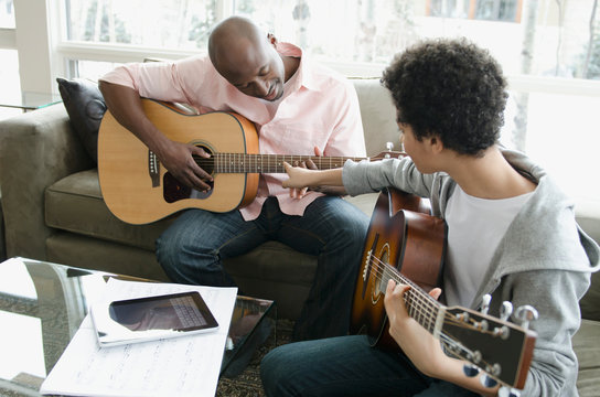 father and son playing guitars together