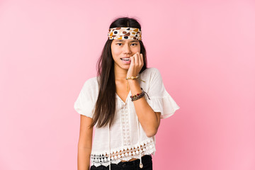 Young chinese hippie isolated biting fingernails, nervous and very anxious.