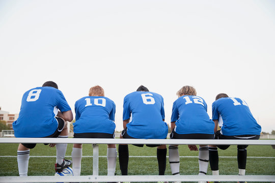 View from behind of soccer players on bench.