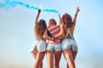 Group of girls with American flag. Young female friends with USA flag at park celebrating 4th of...