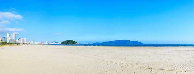 Panoramic view of a brazilian Paulista beach with a huge band of waterfront sand on beautiful day....