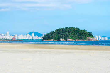 View of the coastal city of Santos SP seen through the perspective of Praia do Itarare beach, in Sao Vicente SP. Touristic brazilian cities and beaches of the Litoral Paulista coast.