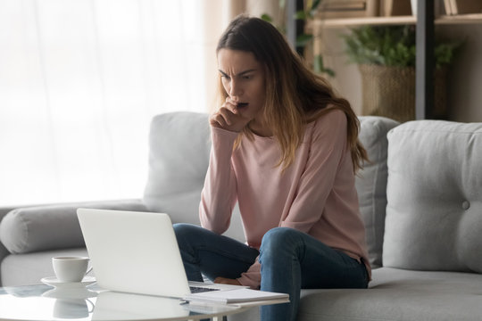 Negatively Surprised Frowning Young Lady Irritated By Computer Problem.