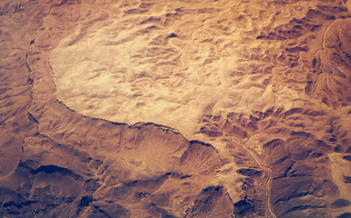 Aerial view on reliefs of a stone desert in the Africa. Mountain landscape with mountain peaks and hills as abstract background for your project presentation about geography or travels.