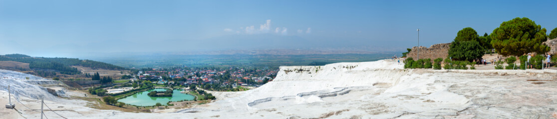 Fototapeta na wymiar Panorama of the unique Pamukkale natural complex with white cliffs, an emerald lake, a picturesque village, ancient ruins and a beautiful valley.