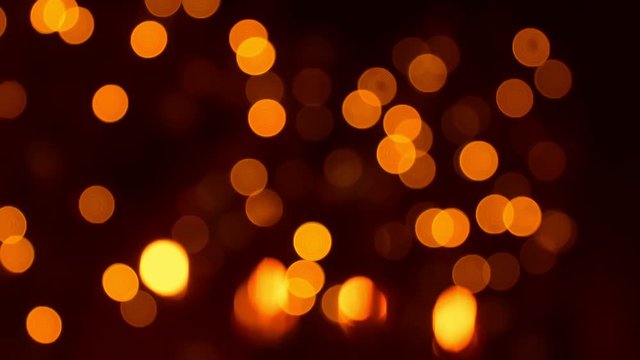 Christmas atmosphere, golden bokeh and garland lights at night, new year decorations twinkling fast, lighting up and fading out by yellow and orange colors, abstract holiday background