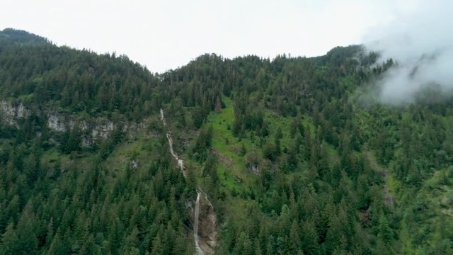 Scenic Aerial View of Waterfall in Mountains with Forest and Steam. Environment Background Footage of Natural Landscape in Alps, Germany. 4K Drone Pedestal Panoramic Shot